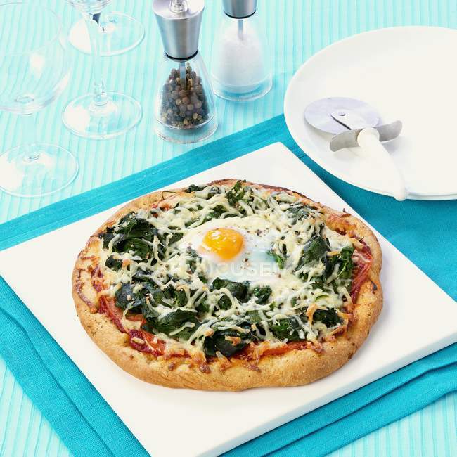 Spinach pizza with fried egg — Stock Photo