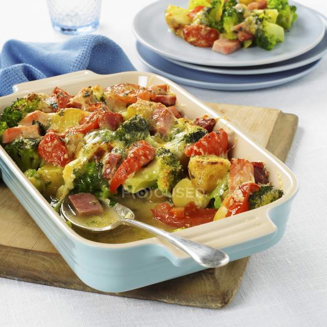 Broccoli e forno kassler - carne di maiale affumicata e salata in piatto bianco con cucchiaio sulla scrivania di legno — Foto stock