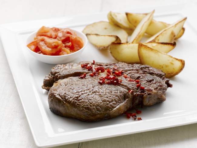 Ribeye steak with potato wedges — Stock Photo