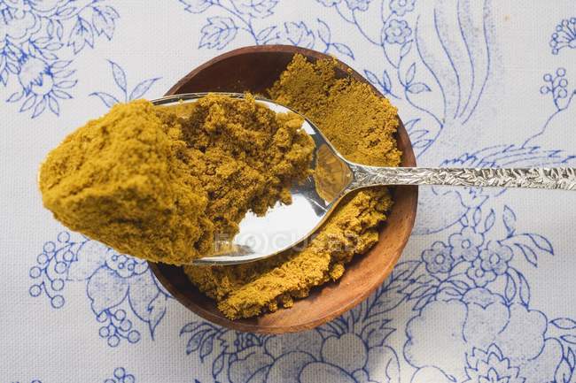 Polvere di curry in boccia e su cucchiaio — Foto stock