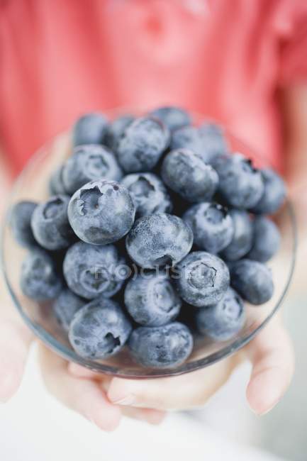 Childs hands holding bowl of blueberries — Stock Photo