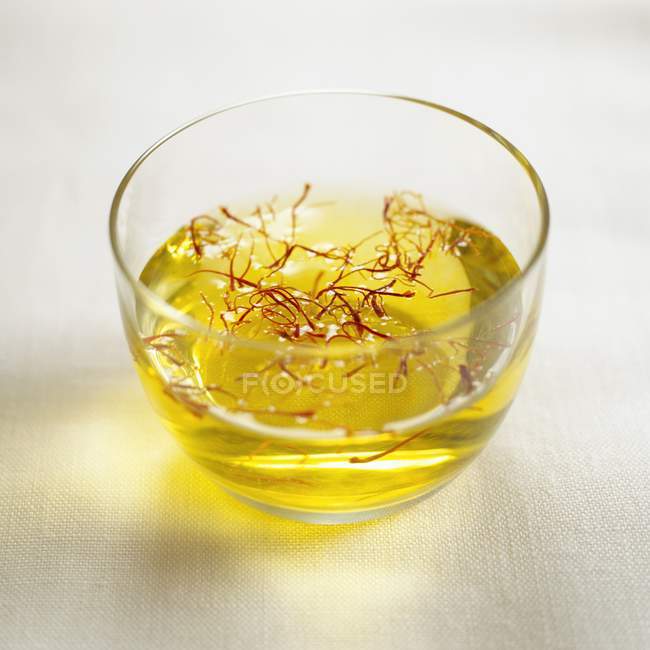 Saffron threads in small bowl of oil — Stock Photo