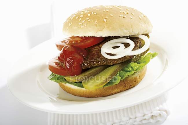 Tasty cheeseburger on plate — Stock Photo
