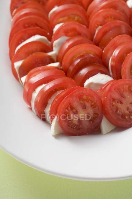 Tomaten und Mozzarella in Scheiben geschnitten — Stockfoto