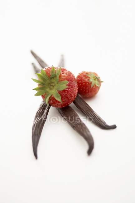 Vanilla pods with strawberries — Stock Photo