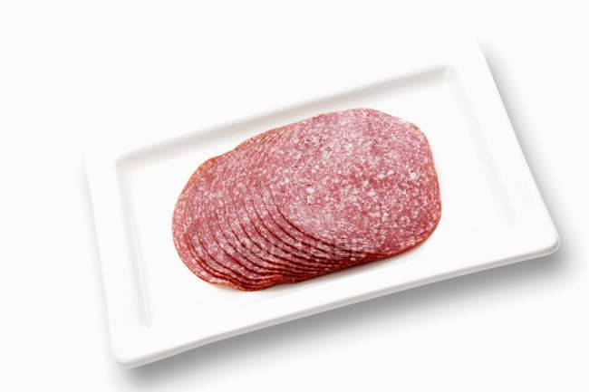 Sliced salami on platter — Stock Photo