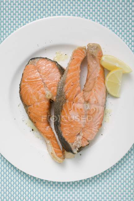 Chuletas de salmón frito con cuñas de limón - foto de stock