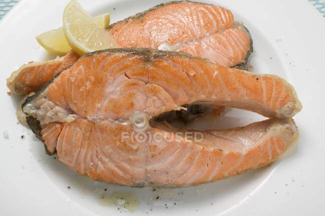 Fried salmon cutlets with lemon wedges — Stock Photo