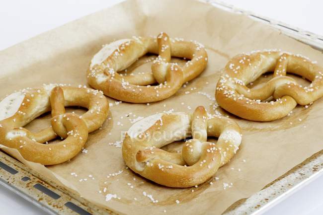 Quatro pretzels em uma assadeira — Fotografia de Stock