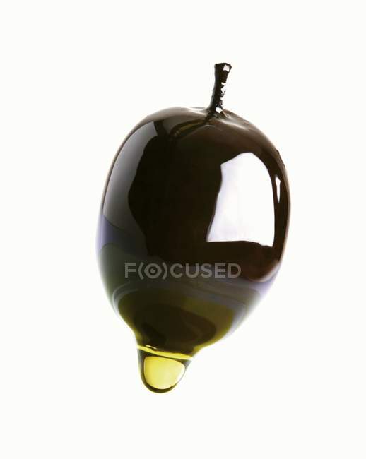 Оливковое масло капает с оливки — стоковое фото