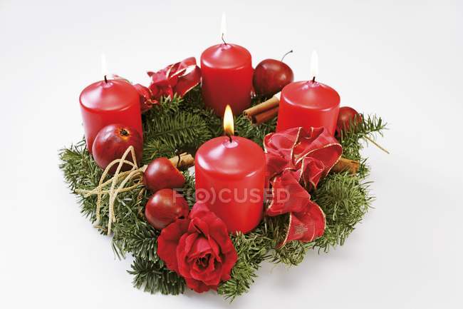 Une couronne de l'Avent avec des bougies rouges sur une surface blanche — Photo de stock