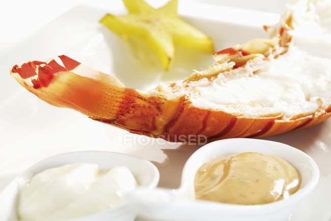 Closeup view of spiny lobster half with dips — Stock Photo