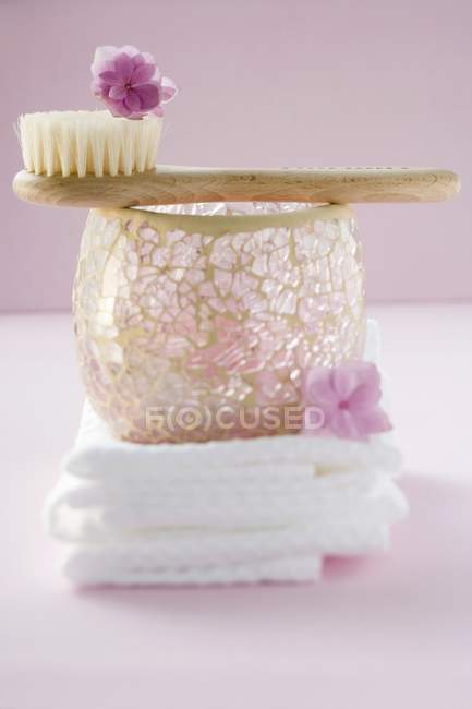 Vista de primer plano de toallas, parabrisas, pincel pequeño y flores - foto de stock