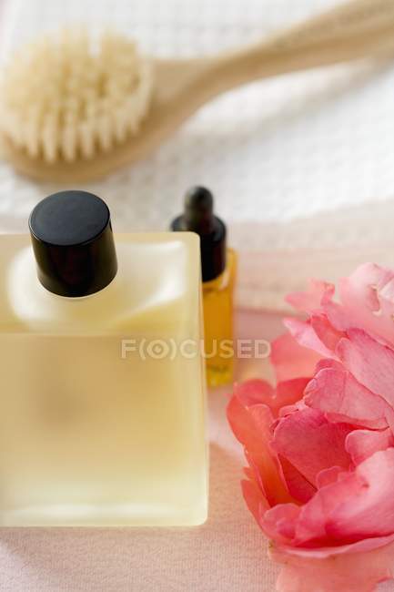 Vista de primer plano de los productos de baño con rosa, toalla y cepillo - foto de stock