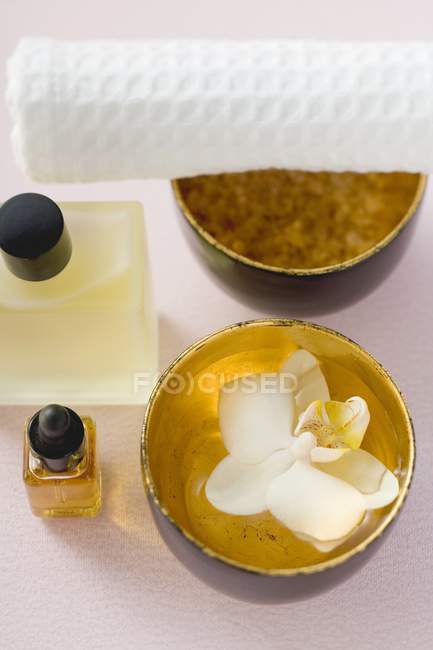 Closeup elevated view of bath products, orchid in bowl of water and towel — Stock Photo