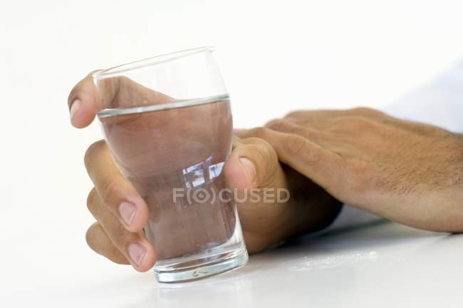 Mano sosteniendo un vaso de agua - foto de stock