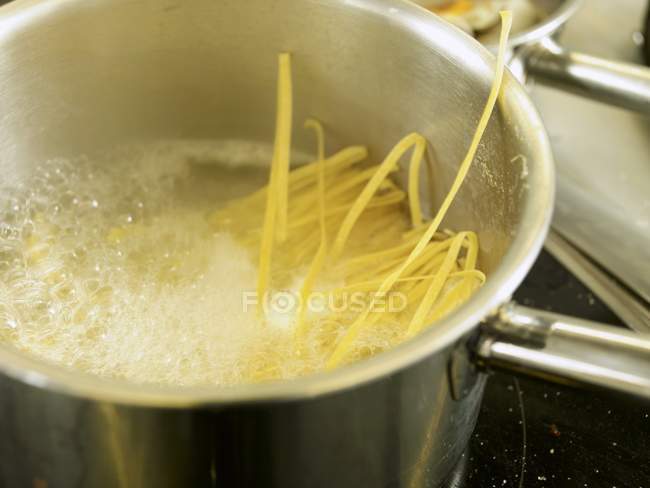Ribbon pasta in boiling water — Stock Photo