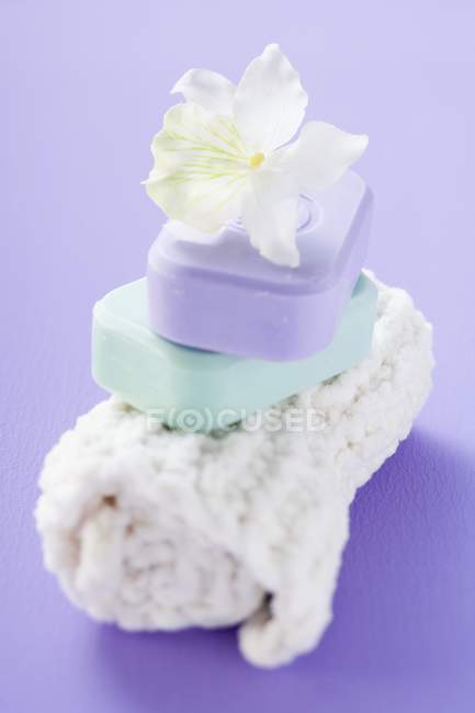 Closeup view of two bars of soap with white orchid on towel — Stock Photo