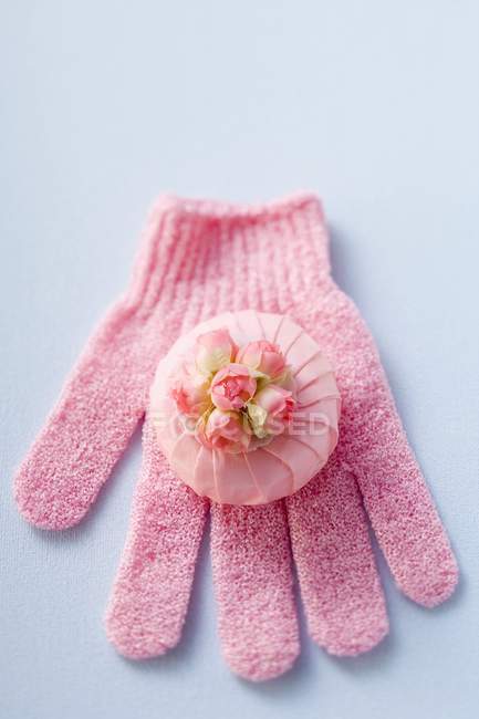 Vista superior de flores de rosa e sabão perfumado na luva rosa — Fotografia de Stock