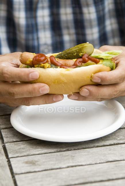 Les mains masculines tenant hot dog — Photo de stock