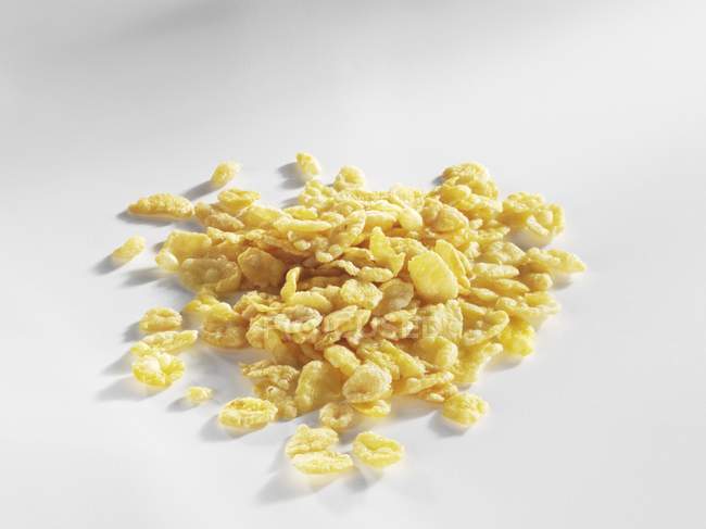 Vista de cerca de un montón de copos de maíz amarillos - foto de stock