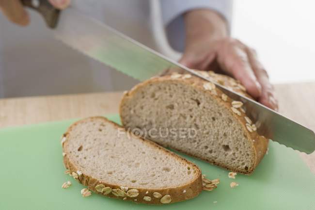 Donna affettare il pane — Foto stock