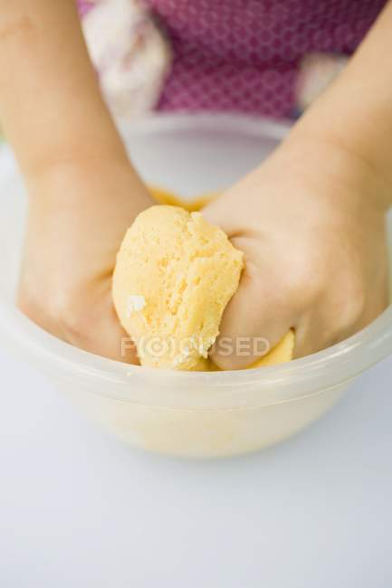 Visão de close-up de mãos de crianças amassando a massa de farinha — Fotografia de Stock