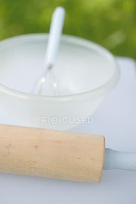 Vue rapprochée du rouleau à pâtisserie avec bol et fouet — Photo de stock