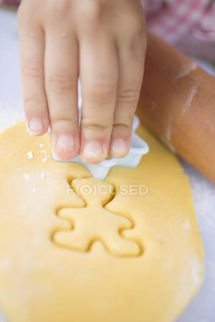 Closeup view of child cutting out a biscuit — Stock Photo