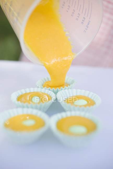 Papierschatullen mit Muffin-Mischung füllen — Stockfoto