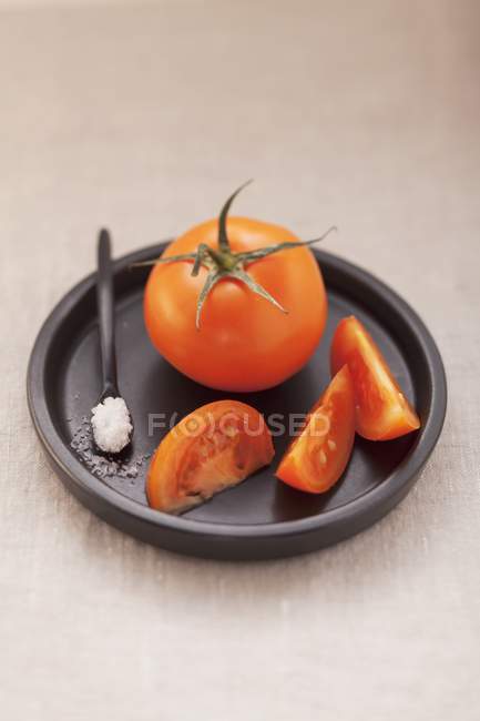 Tomatoes and spoonful of salt — Stock Photo