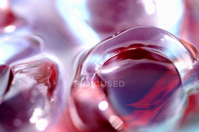 Ice cubes in glass of juice — Stock Photo
