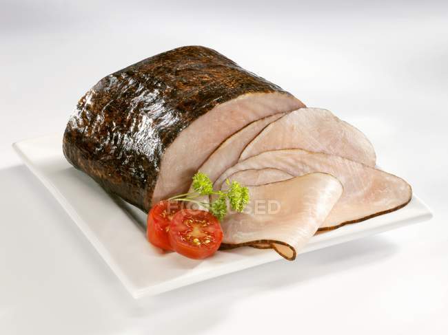 Partly sliced Black smoked ham — Stock Photo