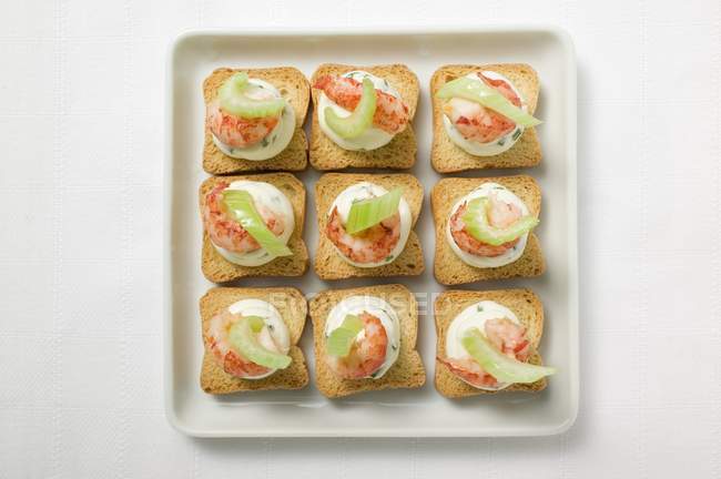 Herb quark, shrimps and celery on toasts — Stock Photo