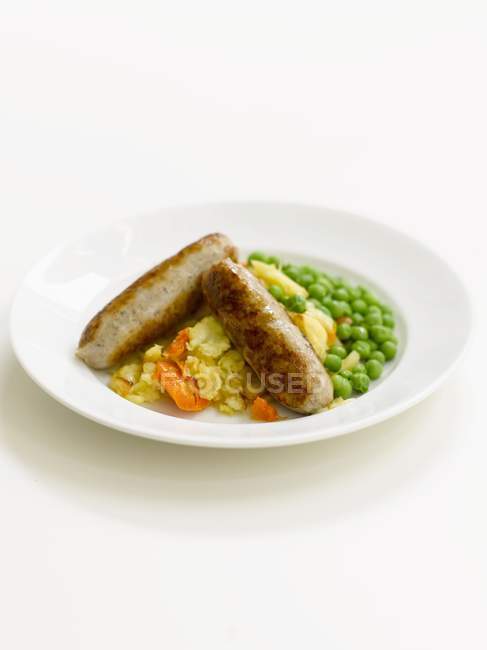 Sausages with potatoes and peas — Stock Photo