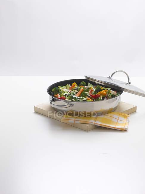 Розпилені овочі на сковороді на білій поверхні — стокове фото