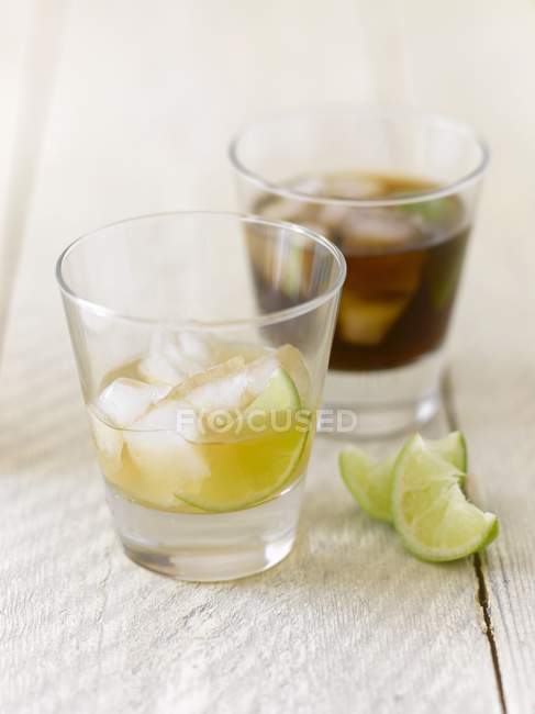 Closeup view of lime drink and cola in glasses — Stock Photo
