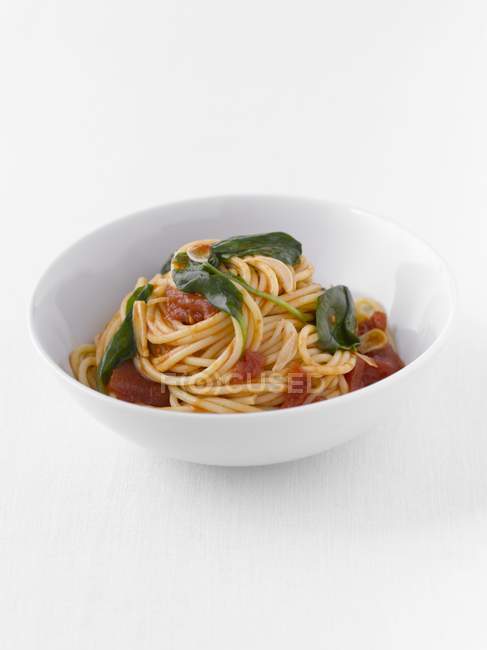 Espaguetis con tomates y albahaca - foto de stock