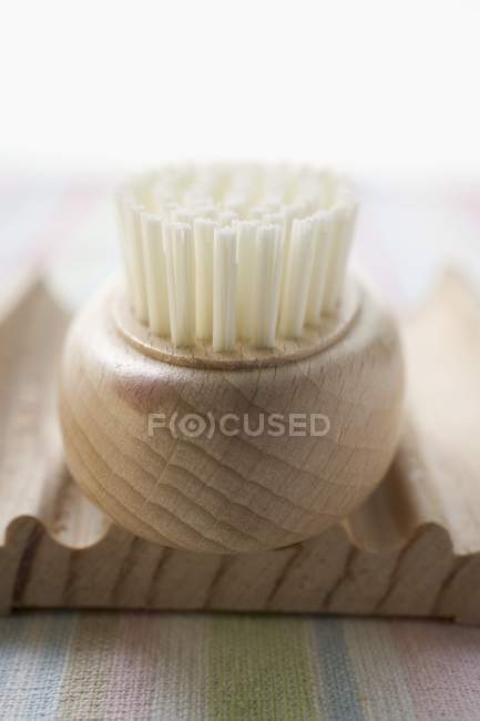 Vista close-up de prato de sabão de madeira com escova — Fotografia de Stock