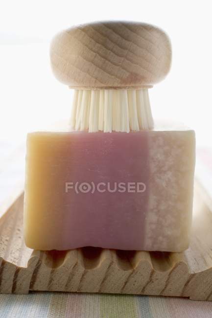 Closeup view of perfumed soap in soap dish with brush — Stock Photo