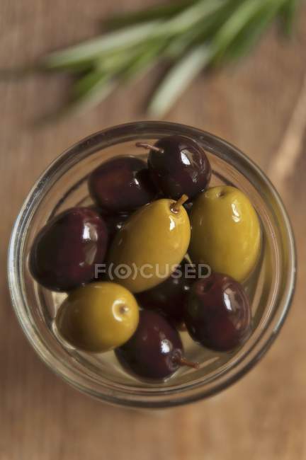 Glas mit schwarzen und grünen Oliven — Stockfoto
