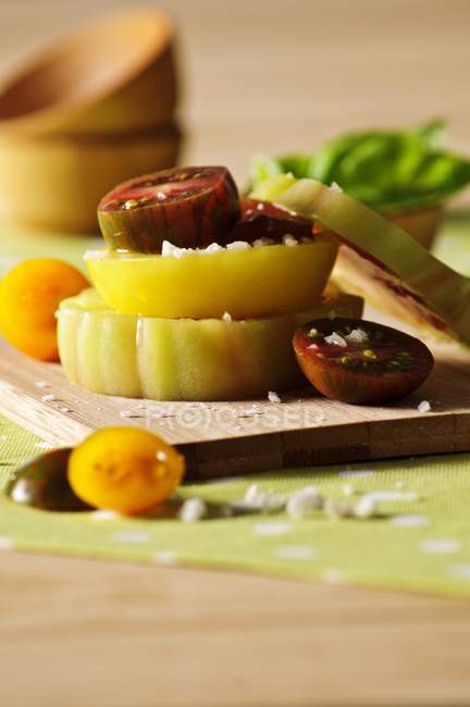 Tomates fatiados em uma tábua de cortar sobre a mesa — Fotografia de Stock