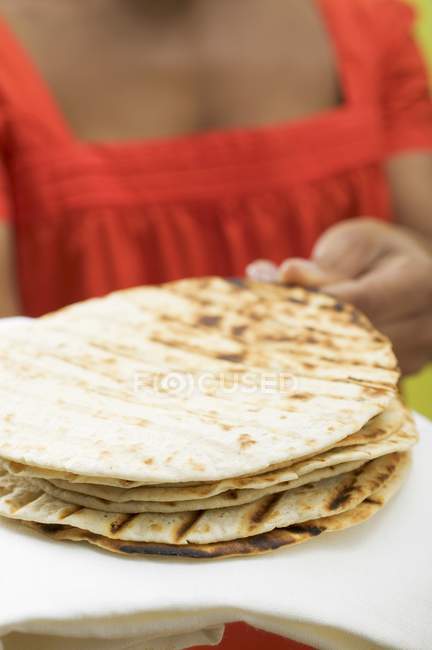 Primo piano vista di donna che tiene un mucchio di tortillas — Foto stock