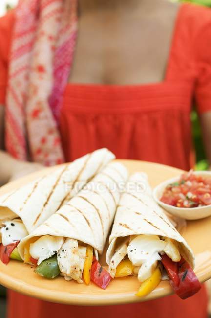 Tagesansicht einer Frau mit einem Teller mit Wraps und Salsa — Stockfoto