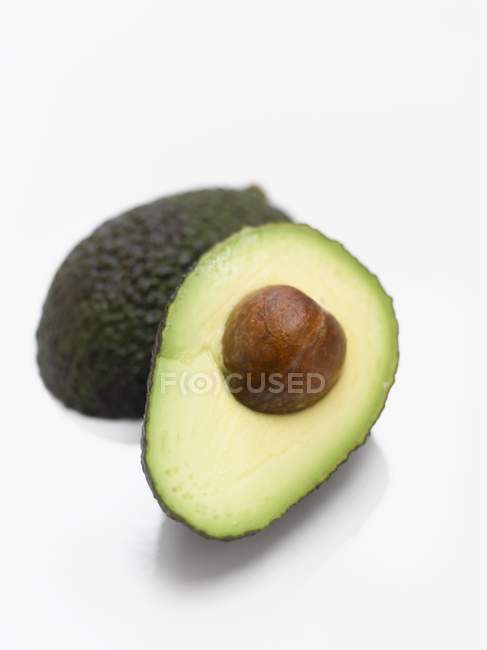 Abacate cortado pela metade com pedra — Fotografia de Stock