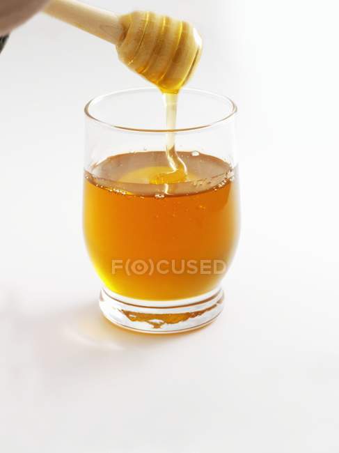 Honey in glass and dipper — Stock Photo