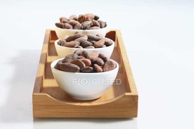 Tazones de granos de cacao - foto de stock