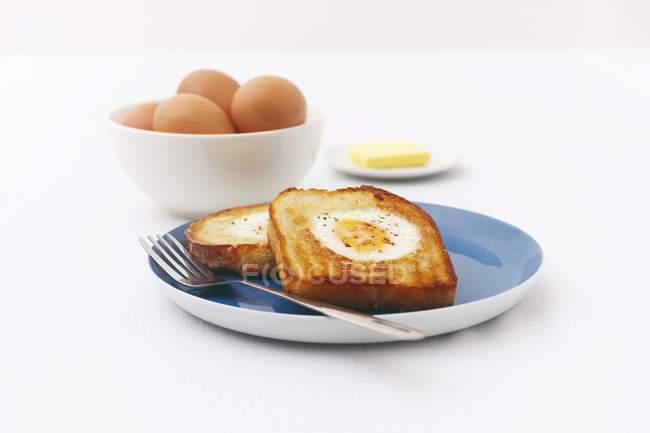 Ovos fritos em torradas com ovos crus e manteiga — Fotografia de Stock