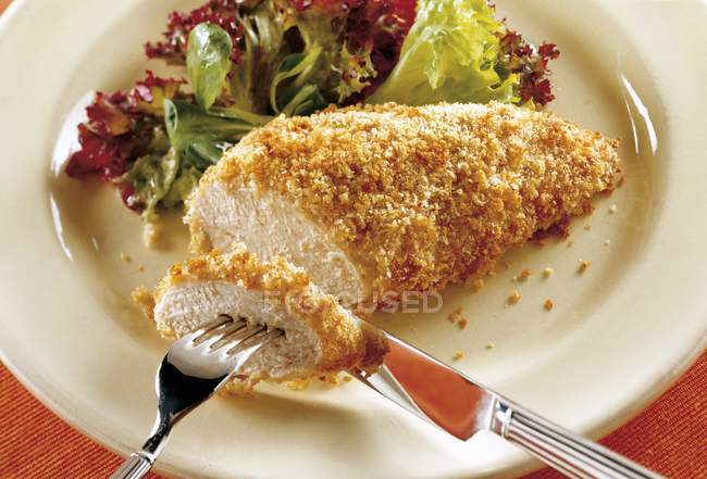 Хлебная курица на тарелке — стоковое фото