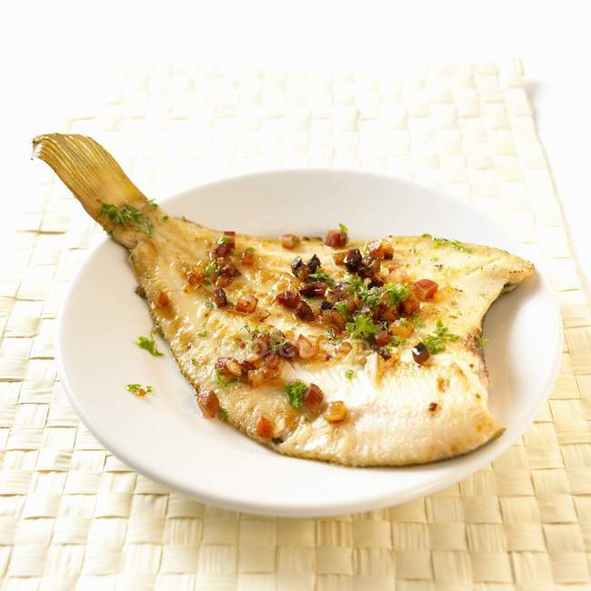 Closeup view of Finkenwerder plaice fish with herbs on white dish — Stock Photo